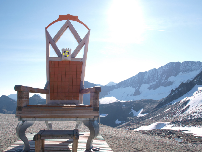 Foto eines freien Throns, dahinter die Berge, die Sonne strahlt.